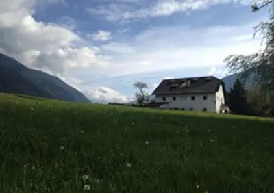 a house in a field with a grassy field at Ansitz Goller in Rasun di Sopra