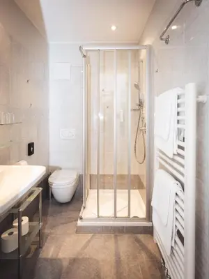 a bathroom with a shower and a toilet and a sink at Hotel Panorama in Rablà