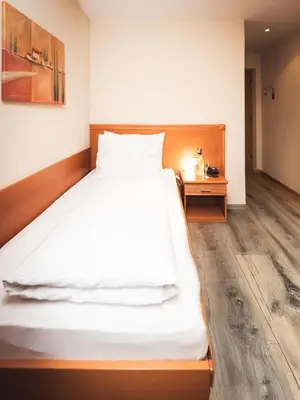 a bedroom with a large bed and a wooden floor at Hotel Panorama in Rablà