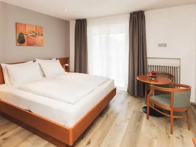 a bedroom with a bed and a table and a chair at Hotel Panorama in Rablà