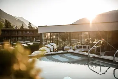 a resort with a swimming pool and a building at Sonnen Resort in Naturno