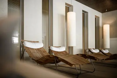 a room with three wicker chairs and mirrors at Sonnen Resort in Naturno
