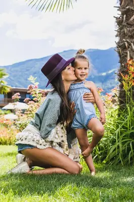 a woman and a child sitting in the grass at Sonnen Resort in Naturno
