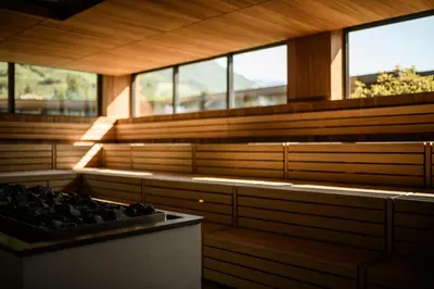 an empty sauna with wooden walls and windows at Sonnen Resort in Naturno