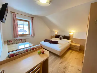 a hotel room with two beds and a couch at Lindnerhof Urlaub am Bauernhof in San Lorenzo di Sebato
