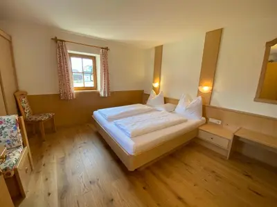 a bedroom with a large white bed and a window at Lindnerhof Urlaub am Bauernhof in San Lorenzo di Sebato