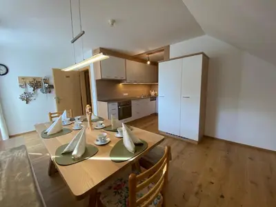 a dining room with a table and a white refrigerator at Lindnerhof Urlaub am Bauernhof in San Lorenzo di Sebato