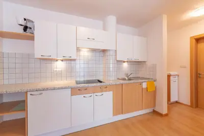 a kitchen with white cabinets and a sink at Residence Trenker Luis in Braies