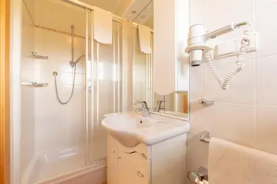 a white bathroom with a sink and a shower at Residence Trenker Luis in Braies