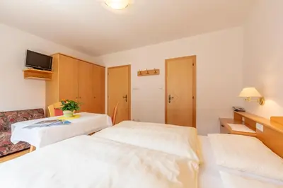 a hotel room with two beds and a tv at Residence Trenker Luis in Braies