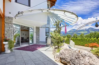 a home with a patio with an umbrella at Mineralienhotel Natznerhof in Naz-Sciaves