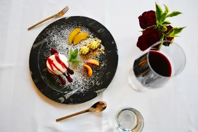 a black plate with a dessert on a table at Mineralienhotel Natznerhof in Naz-Sciaves