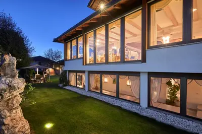 a house with large windows and a green yard at Mineralienhotel Natznerhof in Naz-Sciaves