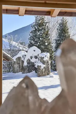 a view through a window of a snow covered yard at Mineralienhotel Natznerhof in Naz-Sciaves