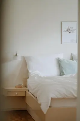 a bedroom with a white bed with a night stand at Wanda Apartments in Parcines