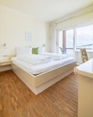 a large white bed in a room with a window at Wanda Apartments in Parcines