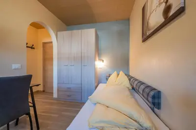 a hotel room with a bed and a bathroom at Appartements Sigmair in Valdaora