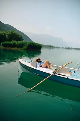 a woman laying in a boat on the water at Leuchtenburg am See in Caldaro