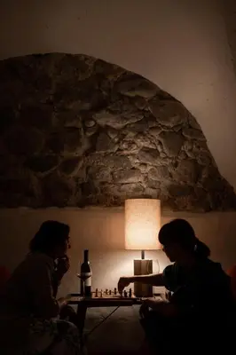 two women playing chess in front of a table with a lamp at Leuchtenburg am See in Caldaro