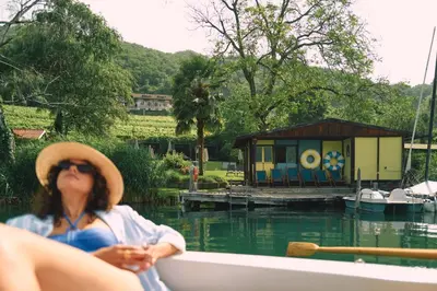 a woman sitting in a boat on the water at Leuchtenburg am See in Caldaro