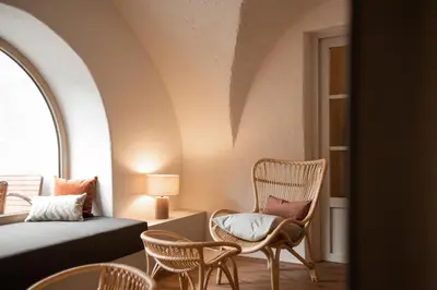 a room with a bed and chairs and a window at Leuchtenburg am See in Caldaro