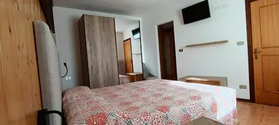 a bedroom with a bed with a red and white blanket at LA CESURA in Carano
