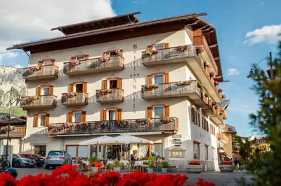 a large building with flowers in front of it at Hotel Aquila in Cortina dʼAmpezzo