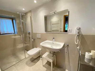 a bathroom with a sink and a shower and a toilet at Matailerhof in Tirolo