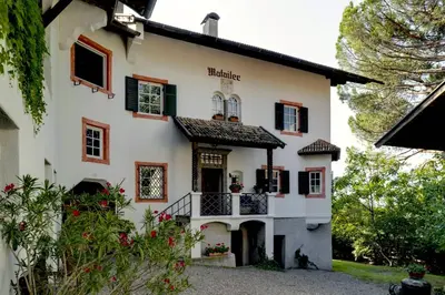 a large white house with a balcony at Matailerhof in Tirolo
