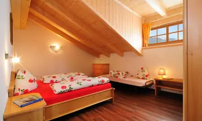 a bedroom with two beds and a window at Steierhof in Feldthurns