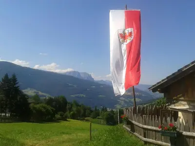 a flag on the side of a wooden fence at Steierhof in Feldthurns