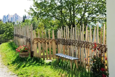 a wooden fence with a bench in front of it at Steierhof in Feldthurns