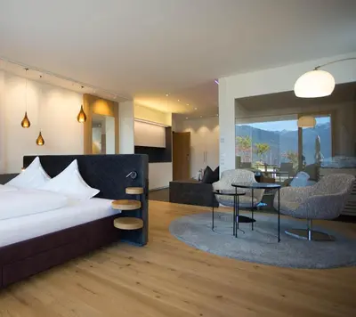 a bedroom with a bed and a living room at Villa Grüntaler by Hotel Schönblick in Rodengo
