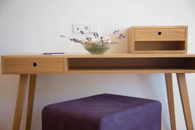 a wooden table with a bowl of flowers on it at Villa Grüntaler by Hotel Schönblick in Rodengo