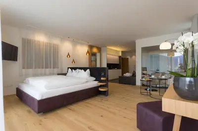 a bedroom with a large bed and a living room at Villa Grüntaler by Hotel Schönblick in Rodengo