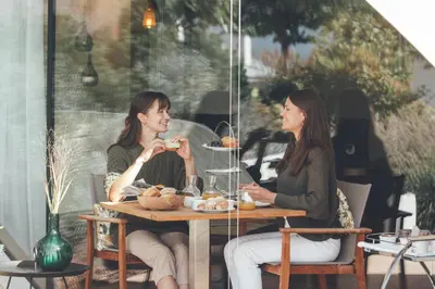 two women sitting at a table eating food at Villa Grüntaler by Hotel Schönblick in Rodengo