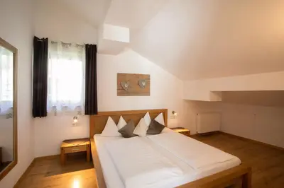 a bedroom with a large white bed in a attic at Residence Untermösslhof in Lana