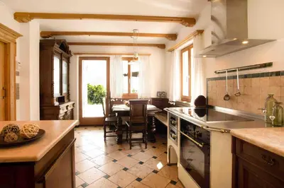 a kitchen with a table and a dining room at Residence Untermösslhof in Lana