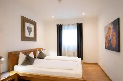 two beds in a room with a window at Residence Untermösslhof in Lana
