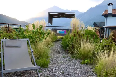 a chair in a garden with mountains in the background at Gapphof in Lagundo