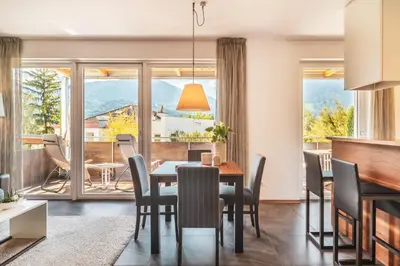 a dining room with a table and chairs and a large window at Hidalgo Suites in Postal