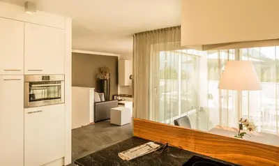 a kitchen with white cabinets and a large window at Hidalgo Suites in Postal