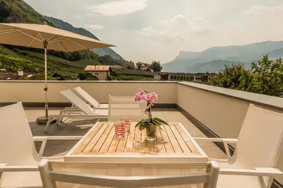 a table with a vase of flowers on a balcony at Hidalgo Suites in Postal