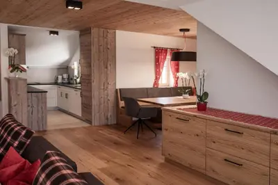 a kitchen and living room with a desk and a table at Penthouse Chalet Pichlerhof in Brunico