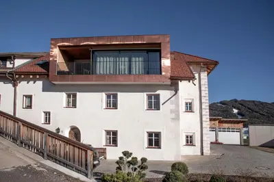 a large white building with a balcony on it at Penthouse Chalet Pichlerhof in Brunico