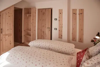 a bedroom with a bed and some wooden wardrobes at Penthouse Chalet Pichlerhof in Brunico