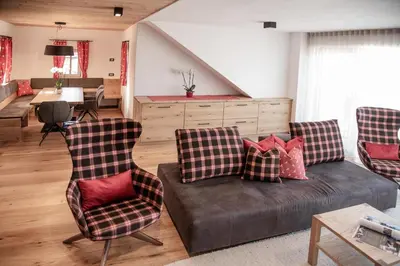 a living room with a couch and two chairs at Penthouse Chalet Pichlerhof in Brunico