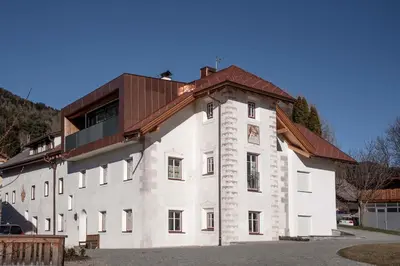 a large white building with a brown roof at Penthouse Chalet Pichlerhof in Brunico