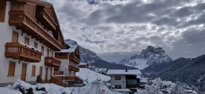 a view of a snow covered mountain with buildings at Vista Pelmo in Colle Santa Lucia