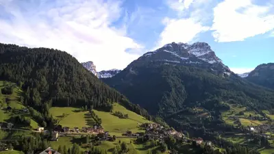 a green valley with a village in front of a mountain at Vista Pelmo in Colle Santa Lucia